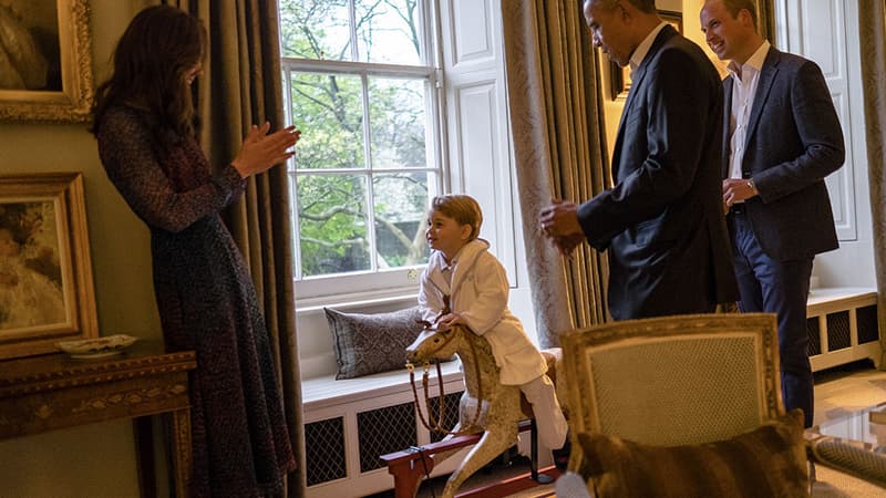 Le prince George, au Palais de Kensington, entouré de ses parents, le prince William et la duchesse de Cambridge, et de Barack Obama, président des Etats-Unis.