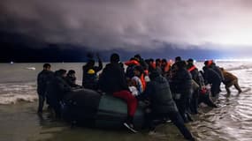 Des migrants montent à bord d'un canot gonflable pour tenter de traverser la Manche, sur la plage de Blériot à Sangatte (Pas-de-Calais) le 30 octobre 2024