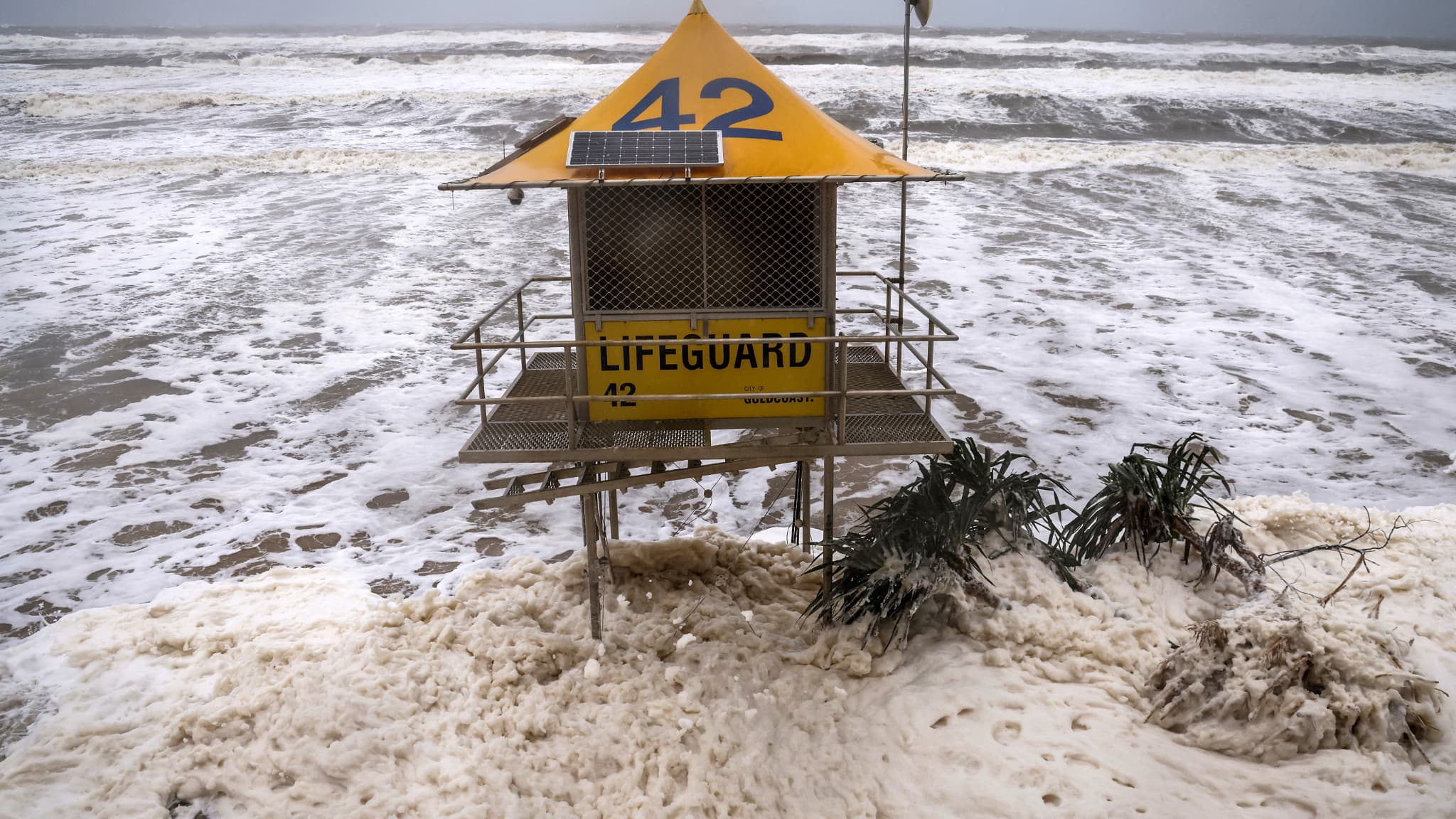 Une tour de sauvetage est entourée d'eau sur la plage principale qui a été endommagée par des vagues record causées par la frange extérieure du cyclone tropical Alfred sur la Gold Coast le 8 mars 2025