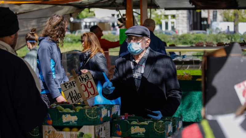 Une homme se protège avec un masque sur un marché de Berlin, le 17 avril 2020