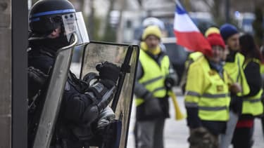 Un CRS fait face à des gilets jaunes, lors de leur 13e mobilisation à Paris le 9 février