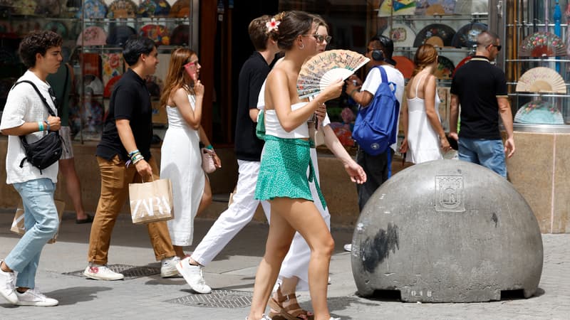 Une femme s'évente pour se rafraîchir en pleine vague de chaleur à Madrid, le 9 août 2023. 