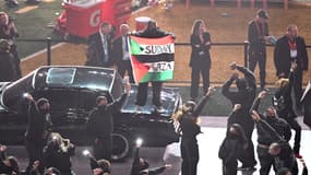 Un danseur affiche un drapeau palestinien avec les inscriptions "Soudan" et "Gaza" lors du show de Kendrick Lamar à la mi-temps du SuperBowl 2025, le 9 février 2025
