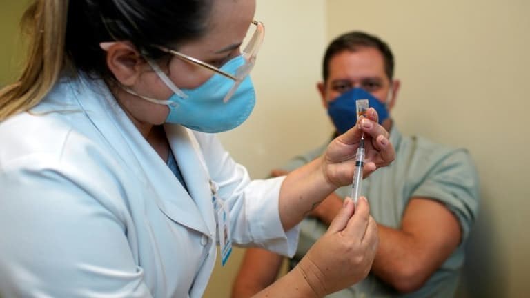 Une infirmière s'apprête à vacciner un homme à Niteroi, Brésil, le 19 janvier 2021