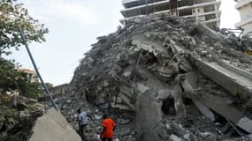Des personnes tentant de retrouver des survivants dans l'immeuble qui s'est effondré à Lagos (Nigeria) le 1er novembre 2021.