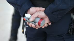 Un membre des forces de l'ordre tient une grenade lacrymogène lors d'une manifestation de gilets jaunes, en février 2019 (PHOTO D'ILLUSTRATION)