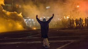 Un manifestant fait face aux forces de police, sous les nuages de gaz au poivre, le 28 avril, à Baltimore. 