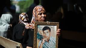 Une Palestinienne avec la photo d'un prisonnier en Israël, lundi 12 août à Gaza.