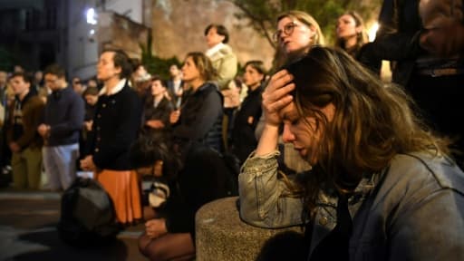 Parisiens et touristes chantant et priant pendant que Notre Dame est en flammes, à Paris, le 15 avril 2019