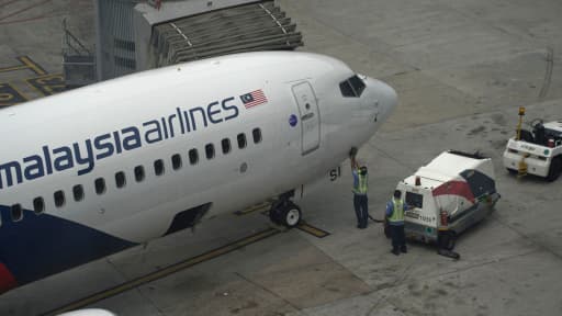 Un avion de la Malaysia Airlines est inspecté sur le tarmac de l'aéroport de Kuala Lumpur, le 13 mars 2014.