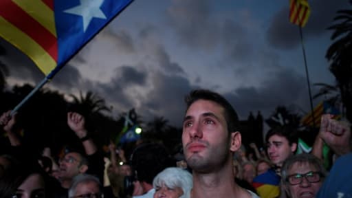 Des partisans de l'indépendance de la Catalogne écoutent le discours de Carles Puigdemont diffusé sur un écran devant l'Arc de Triomphe de Barcelone, le 10 octobre 2017