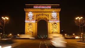 Les visages des deux journalistes français otages en Afghanistan Stéphane Taponier et Hervé Ghesquière ont été projetés sur les piliers de l'Arc de Triomphe, à Paris, mercredi à l'aube pour marquer leur première année de détention. /Photo prise le 29 déce