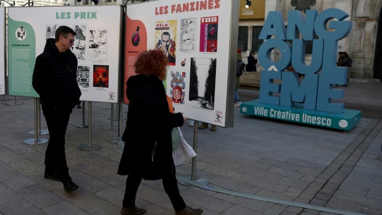Des visiteurs regardent des affiches dans le cadre d'une exposition lors du 52e Festival international de la bande dessinée d'Angoulême, le 30 janvier 2025