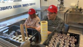 Mario (à droite) et sa mère (à gauche) mettent les étiquettes sur les pots des confitures qu'ils ont cuisinées.