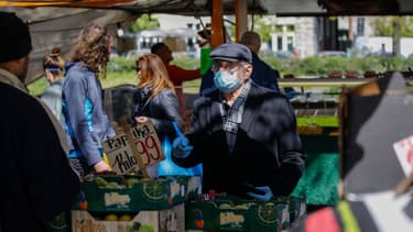 Une homme se protège avec un masque sur un marché de Berlin, le 17 avril 2020