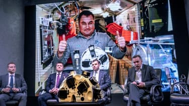 Une photo du cosmonaute russe Oleg Skripochka posant avec l'imprimante 3D est projetée lors d'une conférence de presse à Moscou