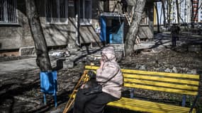 Une femme sur un banc devant un immeuble bombardé à Kharkiv, en Ukraine, le 24 février 2022 (photo d'illustration).
