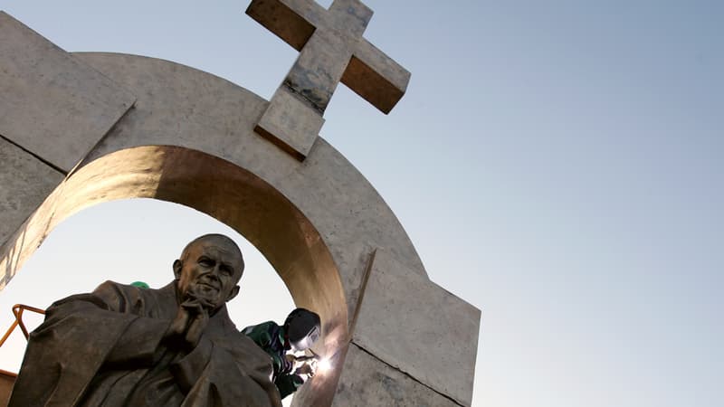 Des ouvriers d'origine russe travaillent à l'installation d'une statue géante du pape Jean-Paul II, le 28 novembre 2006 à Ploërmel.