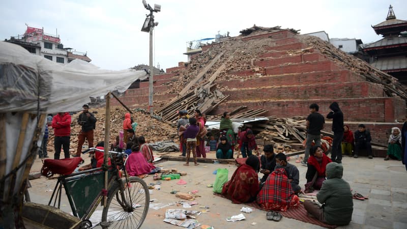 Des Népalais devant des immeubles effondrés, le 26 avril, à Katmandou. 