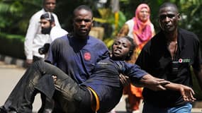 Des hommes évacuent une jeune femme victime des Shebabs à Nairobi, au Kenya.