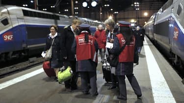 Des agents SNCF attendent à l'arrivée d'un train pour donner aux passagers des formulaires de remboursement.
