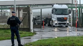 Un CRS surveille la sortie d'un camion-citerne du dépôt TotalEnergies de Flandres, le 13 octobre 2022 à Mardyck, dans le Nord