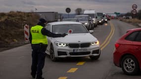 Un policier fait la circulation aux abords de la frontière Medyka, entre l'Ukraine et la Pologne, vendredi 25 février