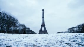 Une photographie prise sur le Champ de Mars à Paris le 9 janvier 2024 montre le grand espace vert public recouvert de neige et la Tour Eiffel.