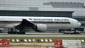 Un Boeing 777-300ER de Singapore Airlines, dont l'aile tribord a été carbonisée par un incendie de moteur lors d'un atterrissage d'urgence, est remorqué sur le tarmac de l'aéroport international de Changi, à Singapour, le 27 juin 2016.