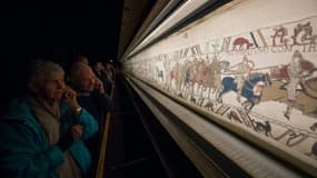 Des visiteurs admirent la tapisserie de Bayeux, exposée dans cette ville du Calvados le 13 septembre 2019