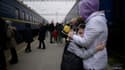 Une femme étreint un enfant avant le départ d'un train de la gare de Zaporijia dans le sud de l'Ukraine le 17 avril 2022