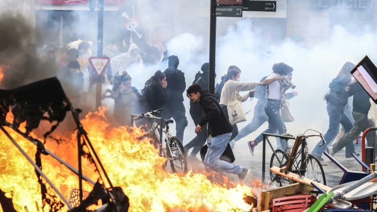 Des manifestants fuient les tirs de gaz lacrymogène en marge d'une manifestation contre les retraites le 23 mars 2023 à Paris