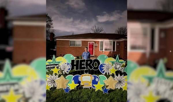 Dillon Reeves, 13 ans, entouré de nombreuses pancartes déposées par ses voisins devant chez lui après qu'il a sauvé ses camarades d'un accident de bus scolaire, dans le Michigan, aux États-Unis