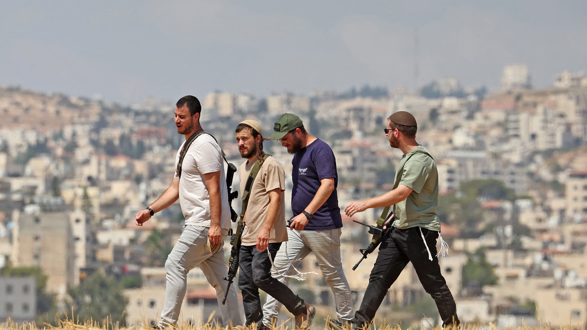 Des colons israéliens traversent un champ à Beit Sahur, au sud de Bethléem, en Cisjordanie occupée, le 14 août 2026. Des colons israéliens traversent un champ à Beit Sahur, au sud de Bethléem, en Cisjordanie occupée, le 14 août 2026.