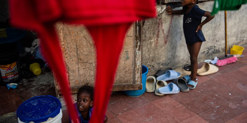 Des enfants jouent devant le Rex Theatre, transformé en refuge pour les personnes déplacées, dans le centre-ville de Port-au-Prince, en Haïti, le 17 juillet 2025. 