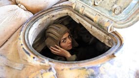 Une militaire syrienne conduit un char à Damas le 25 mars 2015