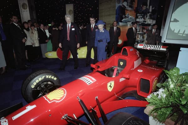 Queen Elizabeth II walks past German Formula 1 driver Michael Schumacher's Ferrari racing car during a visit to the Shell Centre in London on November 11, 1997.
