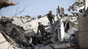 Des pompiers au milieu d'immeubles détruits à Tel-Aviv, en Israël, après des frappes venues d'Iran, le 14 juin 2025