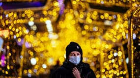 Une femme portant un masque marche sous les décorations de Noël à Moscou le 15 décembre 2020