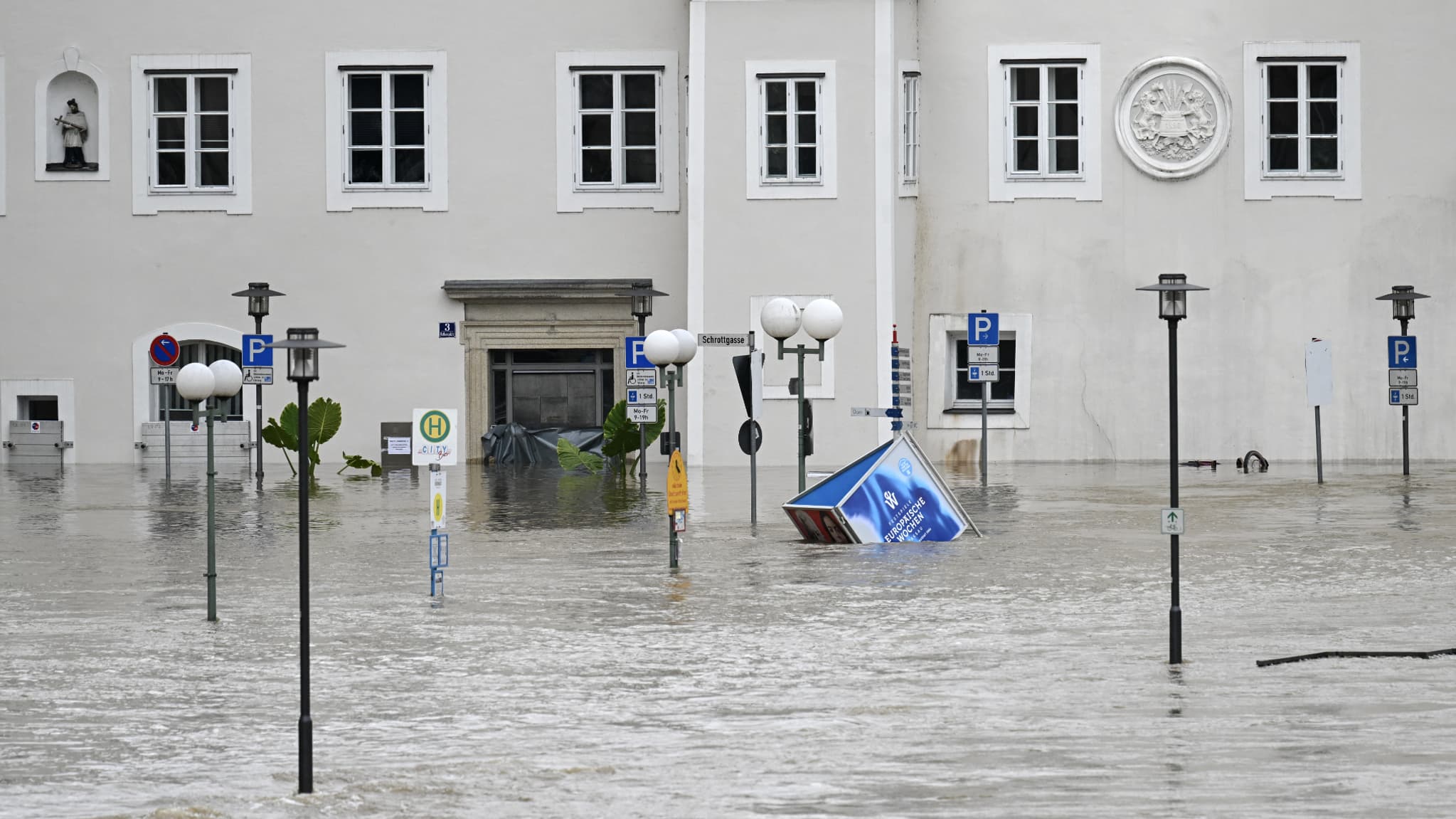 Un panneau d'annonce pour le prochain festival européen de musique de Passau flotte dans les rues inondées du centre de Passau en Bavière, dans le sud de l'Allemagne, une ville entourée par les fleuves Danube et Inn, le 4 juin 2024.