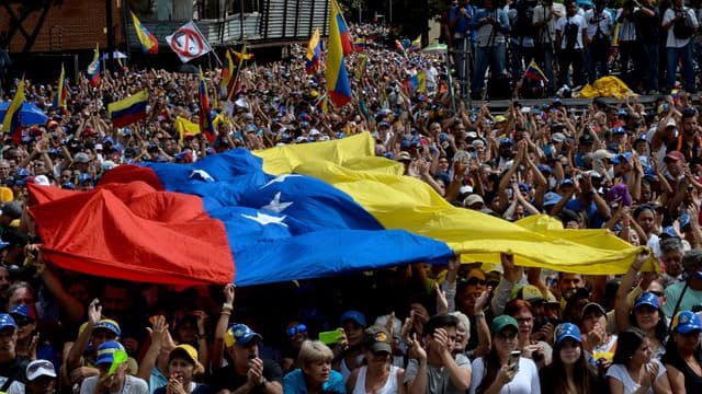 Des vénézuéliens dans les rues de Caracas, écoutent un discours de Juan Guaido le 23 janvier 2019.