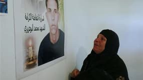 Manoubia Bouazizi, la mère de Mohammed Bouazizi, devant un portrait de son fils dans sa maison de Sidi Bouzid. Le conseil de Paris a décidé de rendre hommage à ce jeune Tunisien, dont l'immolation est considérée comme l'événement déclencheur de la "révolu