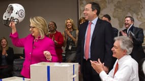 Hillary Clinton, de retour au travail après un mois d'absence, a été ovationné par ses collaborateurs, qui lui ont offert un casque et un maillot de football américain.