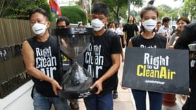Une photo prise par Dailynews montre des militants de Greenpeace en train de livrer à la junte au pouvoir en Thaïlande un sablier en verre symboliquement rempli de l'air pollué de Bangkok, le 22 février 2018
