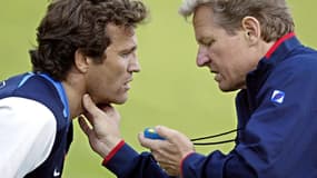 le préparateur physique du XV de France Daniel Servais (D) prend le pouls du capitaine de l'équipe, le demi de mêlée Fabien Galthié, en 2003 au stade Yvon Mattis à Val d'Isère.
