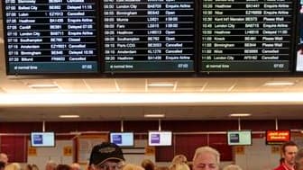 Devant le tableau des départs à l'aéroport d'Edimbourg, en Ecosse. La propagation du nuage de cendres volcaniques a conduit mardi à l'annulation de dizaines de vols en Ecosse et à la fermeture partielle de l'espace aérien danois mais les experts estiment