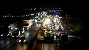 Des agriculteurs français en colère bloque à hauteur de Longjumeau, au sud de Paris, une portion de l'autoroute A6 qui mène à au marché de gros de Rungis, le 30 janvier 2024