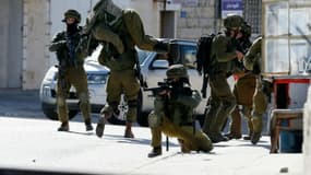 Un soldat israélien porte un de ses collègues blessé après des affrontements avec des Palestiniens dans le camp de réfugiés de Amari, près de Ramallah ke 15 février 2016
