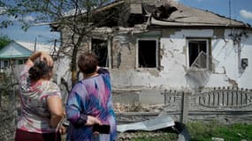 Des femmes observent une maison endommagée par des frappes à Valuyki, dans la région de Belgorod, le 5 juillet 2023