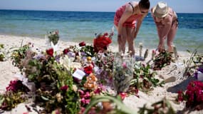 Les touristes se recueillent sur la plage où à eu lieu la tuerie revendiquée par l'EI, le 30 juin 2015.